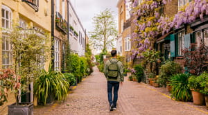 Rear view of a man walking among mews houses in South Kensington district, London, UK